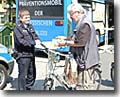 Polizeioberkommissar Bepler am Stand von „Verkehrssicher in Mittelhessen“ mit einem Passanten
