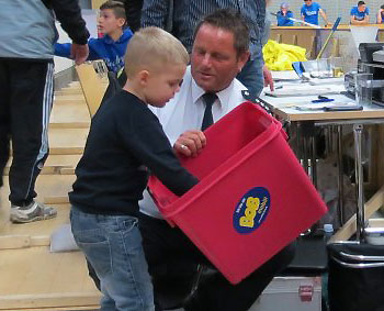 Der dreijährige Elias zieht aus der Losbox von PHK Pfeiffer den Gewinner des Nationaltrikots
