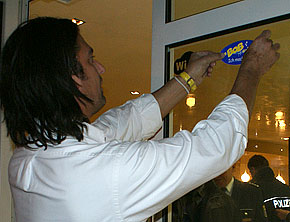 Pablo Antuna bringt an der Eingangstür seiner Venezia Eis-Boutique den BOB-Aufkleber an