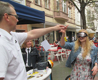 Verwaltungsangestellten Dirk Wussow beim Rauschbrillentest mit einer jungen Dame