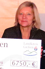Landrätin Anita Schneider mit dem Scheck am Infostand von verkehrssicher-in-mittelhessen mit den Aktionen BOB und MAX