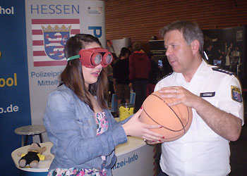 Polizeihauptkommissar Andreas Düding mit einer jungen Damen beim Rauschbrillentest am BOB-Infostand