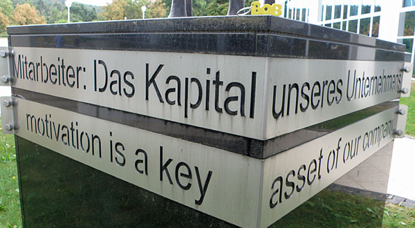 Marmorstele auf dem Geländer der Fa. LOH mit der Inschrift: "Mitarbeiter: Das Kapital unseres Unternehmens" 
