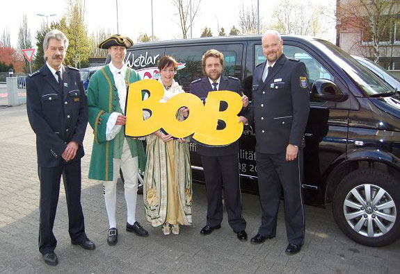 Das Hessentagspaar Nina Becker und Florian Köhler mit dem großen BOB-Schriftzug, beim Besuch auf der Polizeistation in Wetzlar