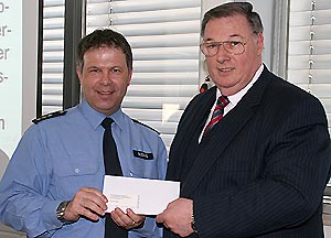 Der Präsident der Handwerkskammer, Herr Werner überreicht einen Spendenscheck an PHK Düding