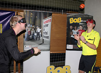 Schiedsrichter Jan-Marvin Herrmann (rechts) und Fabian Bierau, die sich einen Spaß aus dem BOB-Rauschbrillentest machten