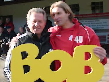 Der 1. Vorsitzende des VfB Wetter Rolf Beuermann (links) mit Buchenaus Trainer, Steffen Schäfer, und dem BOB-Schriftzug