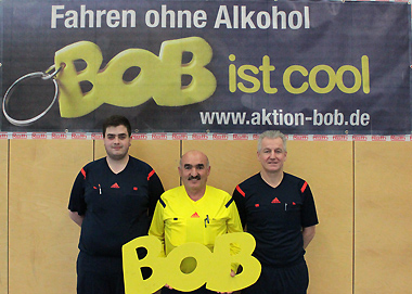 Die Schiedsrichter mit dem BOB-Schriftzug mit v.l. Julian Simon, Halil Yilmaz und Uwe Herrmann beim Turnier des FSV Buchenau in der Hinterlandhalle Dautphetal