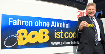 Polizeipräsident Manfred Schweizer mit einem BOB neben einem der Bus-Aufkleber