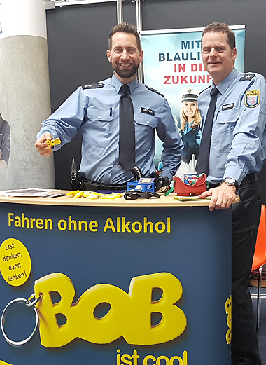 Die beiden Polizeioberkommissare vl. Tobias Decher und Thomas Korbmacher am BOB-Infostand, die Rauschbrille liegt schon für einen Test bereit