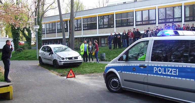 Das Eintreffen der Polizeistreife am nachgestellten Unfallort, moderiert von POK Sill (links)